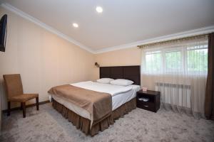瓦纳佐尔Laguna Hotel的卧室配有床、椅子和窗户。