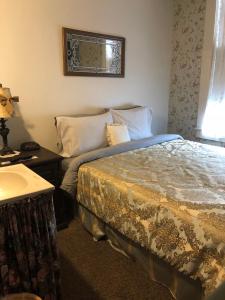 Fort ScottThe Courtland Hotel & Spa的一间卧室配有一张床、一张桌子和一个窗户。