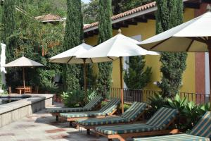 危地马拉安地瓜Villas Catalina的庭院里一排椅子和遮阳伞