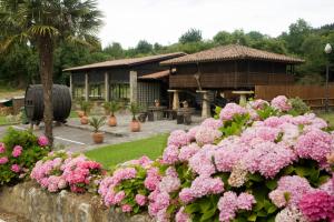 科伦加萨尔夫域酒店的一座花园,在一座建筑前方种有粉红色花卉