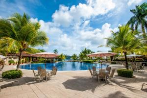 赫拉多拉Los Suenos Resort Veranda 5A by Stay in CR的一个带桌椅的度假村游泳池,并种植了棕榈树