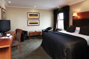 Chryston最佳西方加菲猫家酒店的酒店客房配有一张床、一张书桌和一台电视。