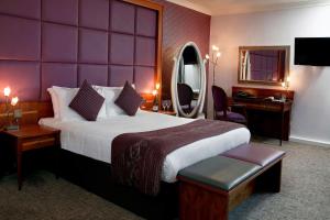 斯凯尔默斯代尔B/W Plus Lancashire Manor Hotel的配有一张大床和镜子的酒店客房