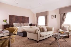 唐克斯特Best Western Premier Doncaster Mount Pleasant Hotel的酒店客房配有一张床、一张沙发和椅子。