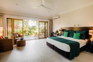 Maninoa辛纳雷礁水疗度假酒店的一间卧室配有一张带绿色枕头的大床