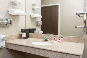 斯特林斯特林速8酒店的浴室的柜台设有水槽和镜子