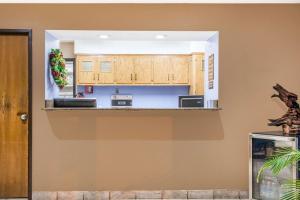 温泉城斯普林斯速8酒店的厨房配有木制橱柜和台面
