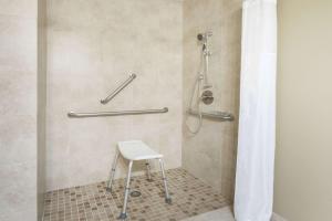 蒙特罗斯蒙特罗斯速8酒店的浴室内配有带凳子的淋浴