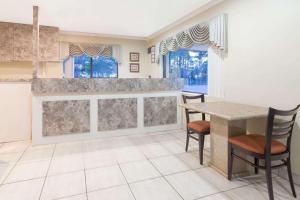 沃尔顿堡滩沃尔顿堡滩速8酒店的厨房配有桌椅和窗户。