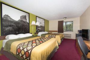 沙德伦Super 8 by Wyndham Chadron NE的酒店客房设有两张床和一台平面电视。