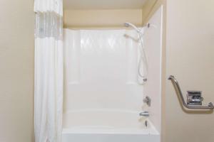 沙德伦Super 8 by Wyndham Chadron NE的浴室内配有白色淋浴帘。