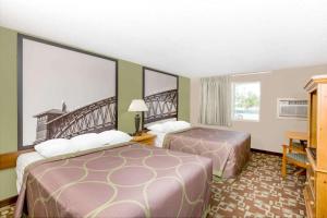 科尔尼Super 8 by Wyndham Kearney的酒店客房设有两张床和一个阳台。
