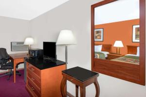 Algona速8阿尔戈纳酒店的酒店客房带一张床、一张书桌和一面镜子
