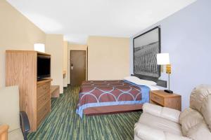 滑铁卢Boarders Inn & Suites by Cobblestone Hotels Waterloo Cedar Falls的酒店客房,配有床和沙发