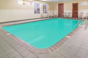 奥法隆奥法伦的速8酒店的游泳池位于酒店房间,周围设有椅子