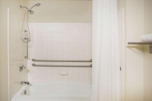 塞勒姆速8塞勒姆酒店的浴室配有淋浴、带浴帘的浴缸