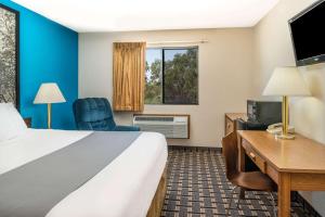林垦林肯西速8酒店的配有一张床和一张书桌的酒店客房