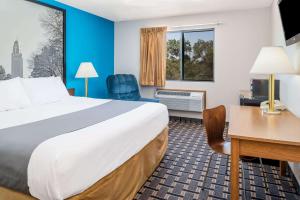 林垦林肯西速8酒店的酒店客房设有一张大床和一张书桌。