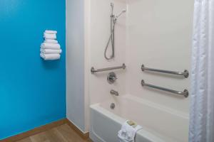 林垦林肯西速8酒店的浴室配有浴缸、淋浴和毛巾。