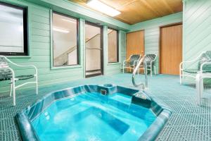 列克星敦列克星敦速8汽车旅馆的一个带椅子和电视的房间的热水浴缸