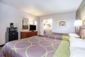 西门罗Super 8 by Wyndham West Monroe的酒店客房设有两张床和一台平面电视。