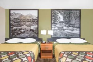里弗顿弗顿速8汽车旅馆的两张位于酒店客房的床,墙上挂着海报