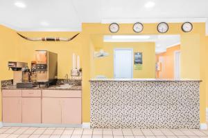 范霍恩范霍恩速8酒店的厨房设有黄色的墙壁和墙上的时钟