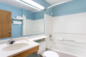 雪松城雪松城速8酒店的一间带水槽、卫生间和镜子的浴室