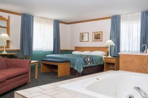 SheldonSuper 8 by Wyndham Sheldon的酒店客房配有一张床和浴缸。