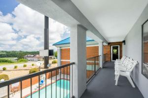 丹德里奇丹德里奇速8酒店 的阳台配有白色椅子和游泳池