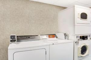 纽波特纽斯戴斯市中心酒店的白色洗衣房配有洗衣机和烘干机