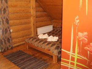 Rumbula韦斯达日酒店的木制客房内的一间卧室,配有一张床
