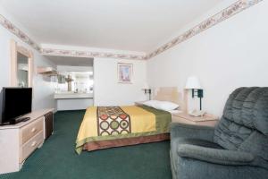 卡顿伍德速8杨木酒店的酒店客房配有床、沙发和电视。