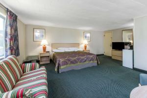 西雅茅斯西茅斯海恩尼斯/科德角速8汽车旅馆的酒店客房,配有一张床和两把椅子