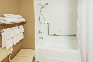 卡尔加里速8酒店卡尔加里机场的浴室配有浴缸、淋浴和毛巾。