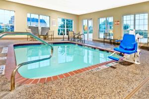 圣安东尼奥圣安东尼奥阿拉莫区速8酒店的一个带蓝色椅子和蓝色椅子的游泳池