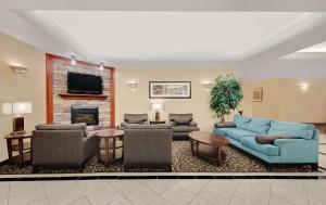 奥德萨Super 8 by Wyndham Odessa TX的客厅设有蓝色的沙发和壁炉
