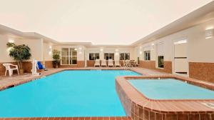 奥德萨Super 8 by Wyndham Odessa TX的一座游泳池,位于酒店客房内,设有大型蓝色游泳池