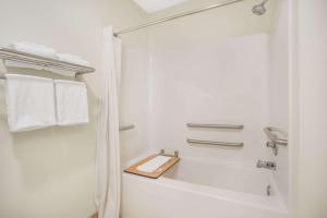 锡达福尔斯锡达福尔斯速8酒店的浴室配有浴缸、淋浴和毛巾。