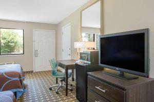 BrinkleySuper 8 by Wyndham Brinkley的酒店的客房配有平面电视和书桌。