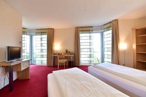 帕德博恩Hotel Aspethera的酒店客房设有两张床和电视。