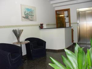 萨米凯莱-迪巴里艾斯贝里阿酒店的一间设有两把椅子和一张桌子的等候室