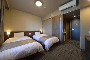 高松多美迎高松中央公园前酒店的酒店客房设有两张床和电视。