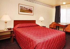 圣克拉拉圣克拉拉伊克诺旅店的酒店客房配有红色的床和书桌
