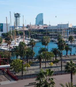 巴塞罗那Serras Barcelona的海港内种有棕榈树和船只的码头