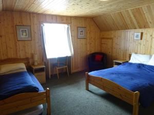 盖尔洛赫Gairloch Sands Youth Hostel的一间卧室设有两张床和窗户。