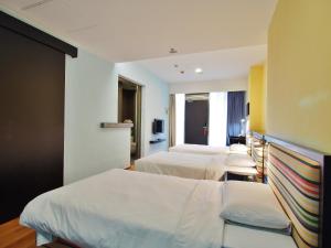 香港Y旅舍的酒店客房设有三张床和电视。