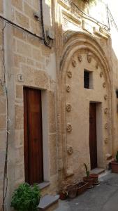 曼杜里亚B&B La Sinagoga的一座有两扇门和盆栽的旧建筑