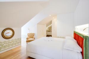 里斯本奥莱亚公寓的卧室配有白色的床和椅子