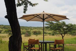 NaboishoBasecamp Wilderness的一张桌子、两把椅子和一把伞